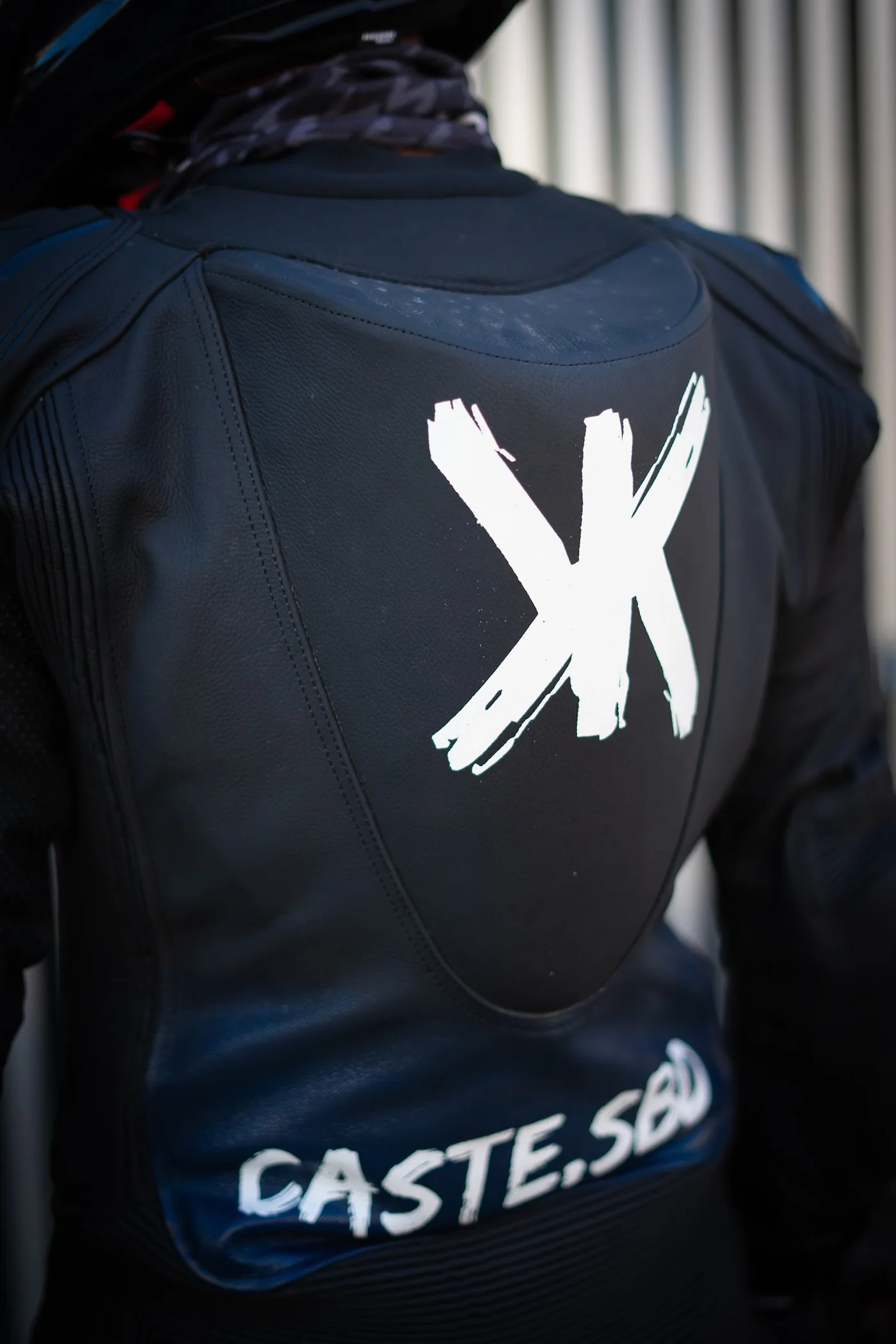 Espalda de un mono azul Doktor con logotipo blanco y nombre personalizado
